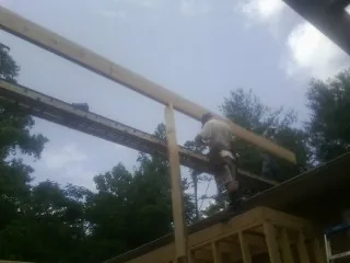 Carpenter setting a ridge beam over a new addition frame — Ice Dam Removal by Roofing Brothers in Mount Morris